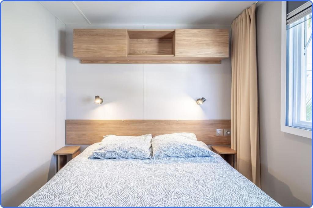 Rúm í herbergi á MOBIL HOME LE LUMINEUX VALRAS