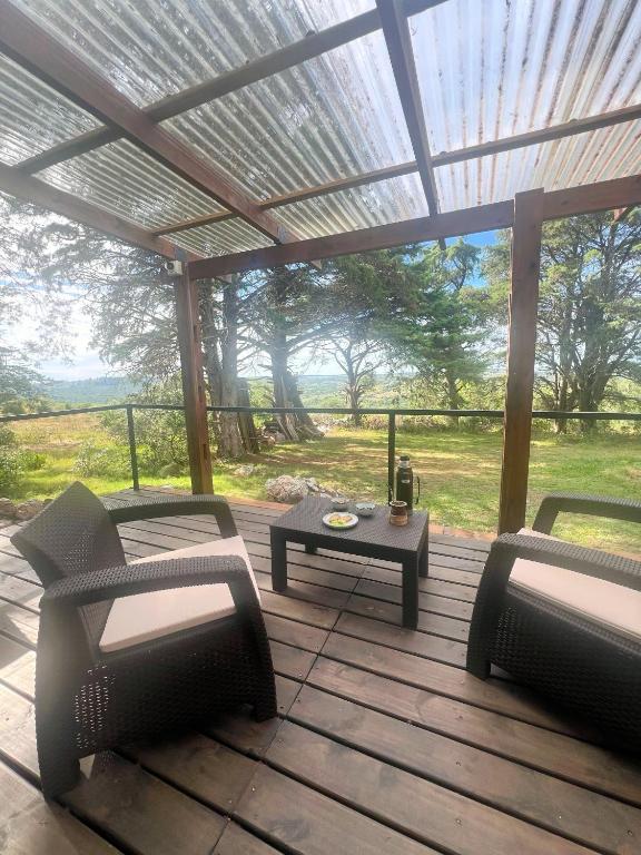 塞拉纳镇NuestroSueño的露台配有两把椅子和一张桌子