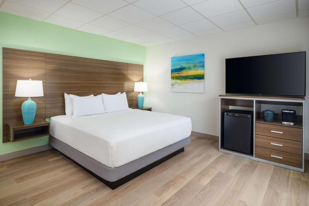 a hotel room with a bed and a flat screen tv at Best Western Naples Inn & Suites in Naples