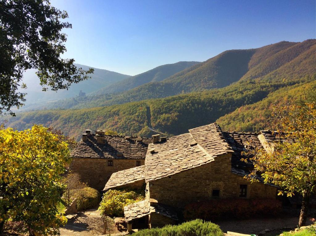un antico edificio in pietra con montagne sullo sfondo di Cortona Village Heights a Cortona