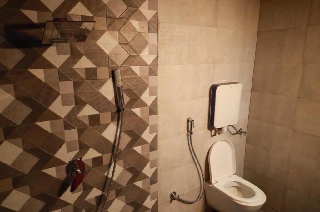 a bathroom with a toilet and a shower at The Lotus Resort Lonavala in Āmbavna