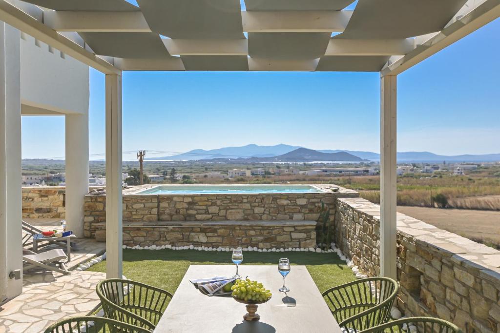 a patio with a table and chairs and a pool at Villa Bazeos in Agkidia