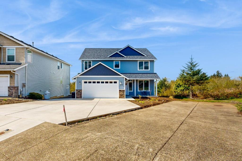 ein blaues Haus mit einer weißen Garage in der Unterkunft Sundown Sanctuary in Tillamook