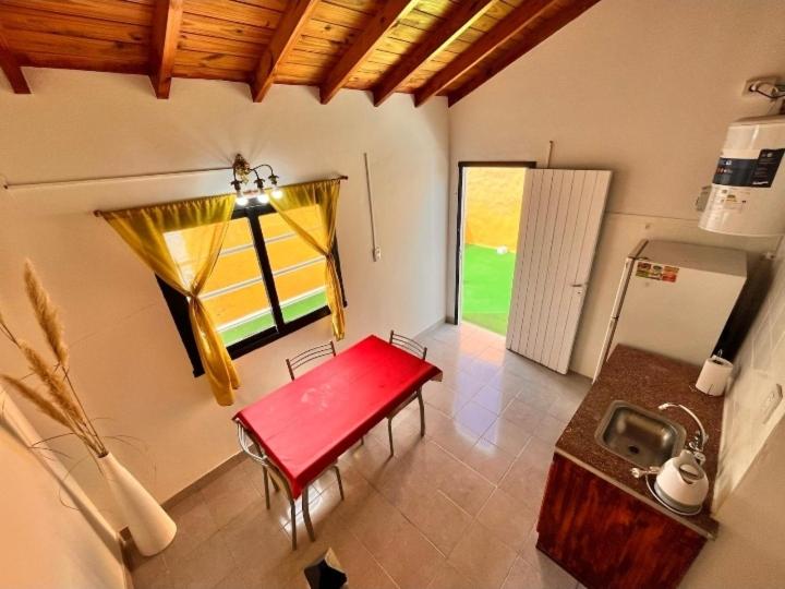 sala de estar con banco rojo y ventana en El silvio descanso, en Mar de Ajó