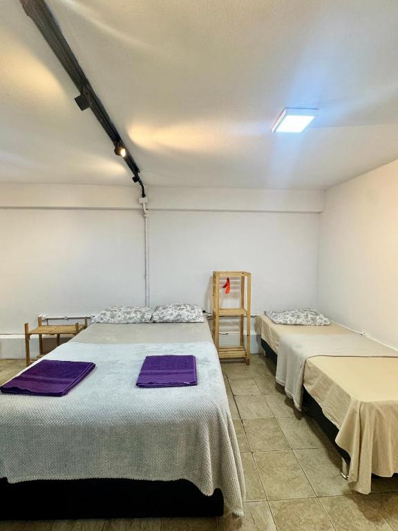 duas camas num quarto com toalhas roxas em Apartemento 101 em Brasília