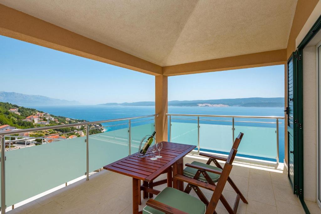 a balcony with a wooden table and two chairs at Apartmani Noah - Mia in Celina