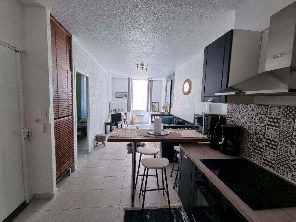 une cuisine avec une table et des chaises dans une pièce dans l'établissement T2 Marseille Panier Vieux Port, à Marseille