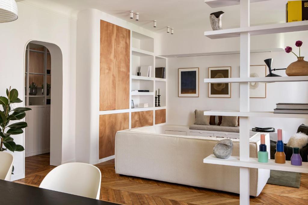 un salon avec un canapé blanc et des étagères dans l'établissement Appartement familial conçu par un architecte, à Levallois-Perret