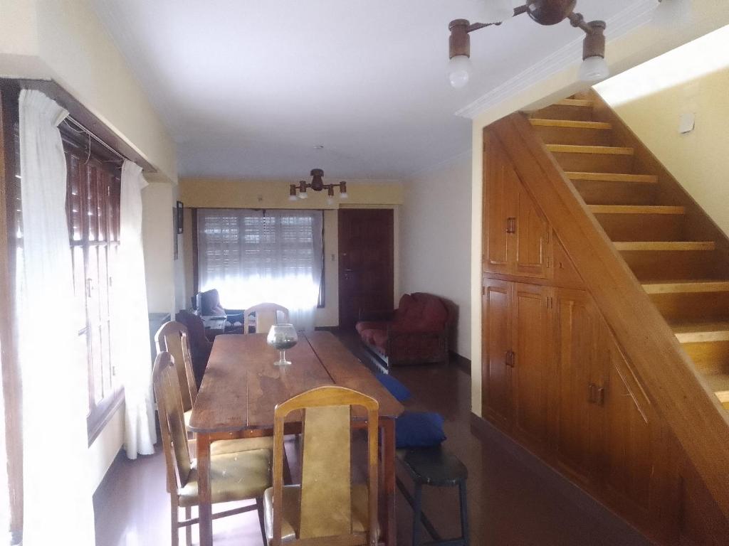 a dining room with a wooden table and stairs at Casa chalet neco in Necochea