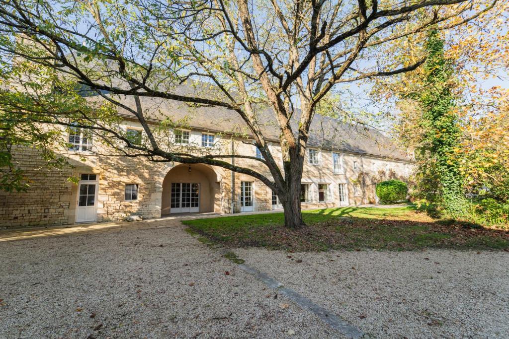 a large stone building with a tree in the driveway at La Maison de Thérèse, Longère 15 people in Bonneuil-Matours