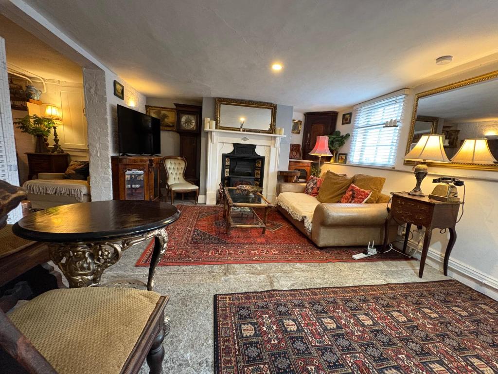 a living room with a couch and a table at Charming Historic Apartment Adjoining Beautiful Central Taunton Park in Taunton