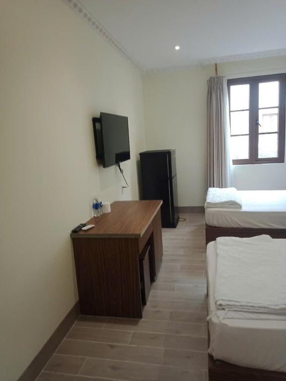 富国Hotel Ven80的一间有床、书桌和电视的房间