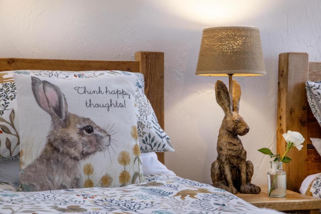 a bed with a pillow with a picture of two rabbits at Mill Cottage in Paignton