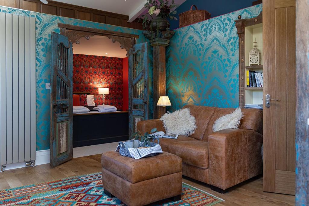 a living room with a couch and a chair at The Artist's Garret in Broadwoodkelly