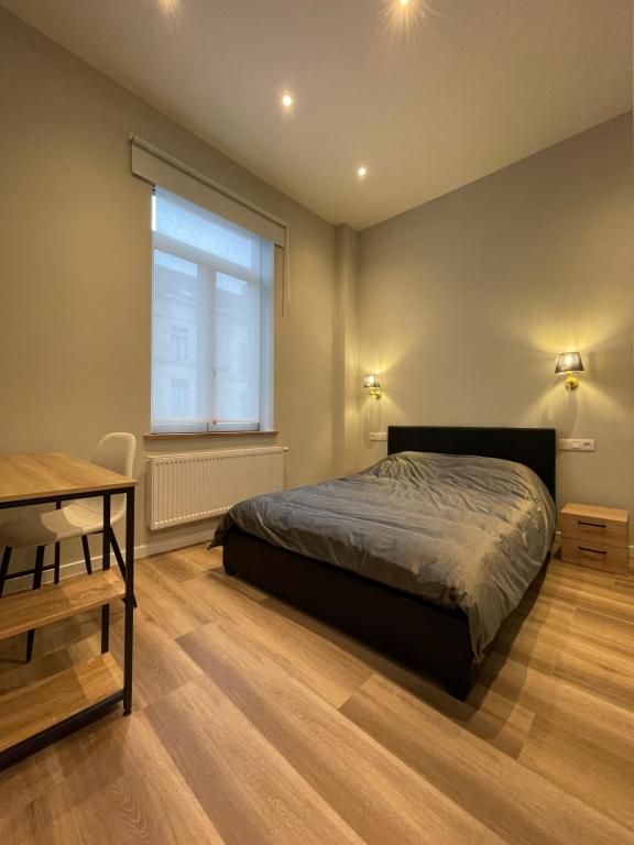 una camera da letto con un letto, una finestra e una scrivania di Midi Station a Bruxelles