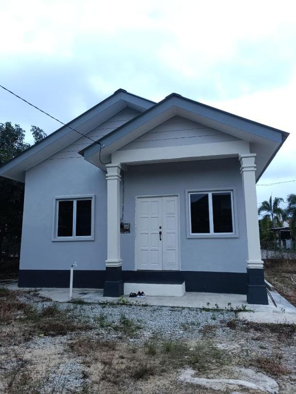 a small white house with a garage at Senja Kelabu Homestay in Kampong Bukit Tok Beng