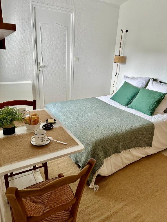 - une chambre avec un lit et une table dans l'établissement Jolie chambre à 2 mn à pied de la plage, à Loctudy