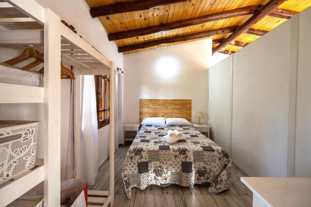 a bedroom with a bed in a room with wooden ceilings at La Calusita Huerta Grande in Huerta Grande