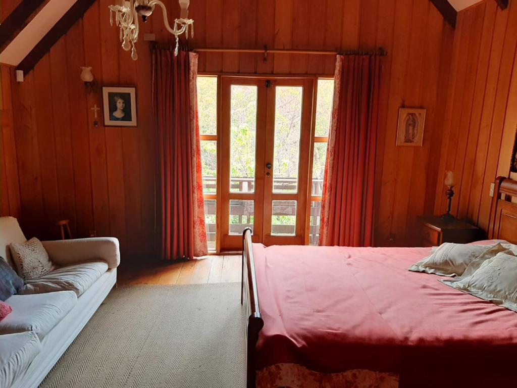 une chambre avec un lit et un canapé dans l'établissement Casa orilla de playa pucón, à Pucón
