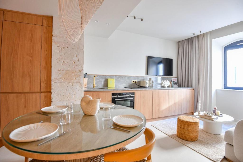 une salle à manger avec une table et une cuisine dans l'établissement L'Adresse 3 - Appart standing - Clim - Vieux-Port, à Marseille