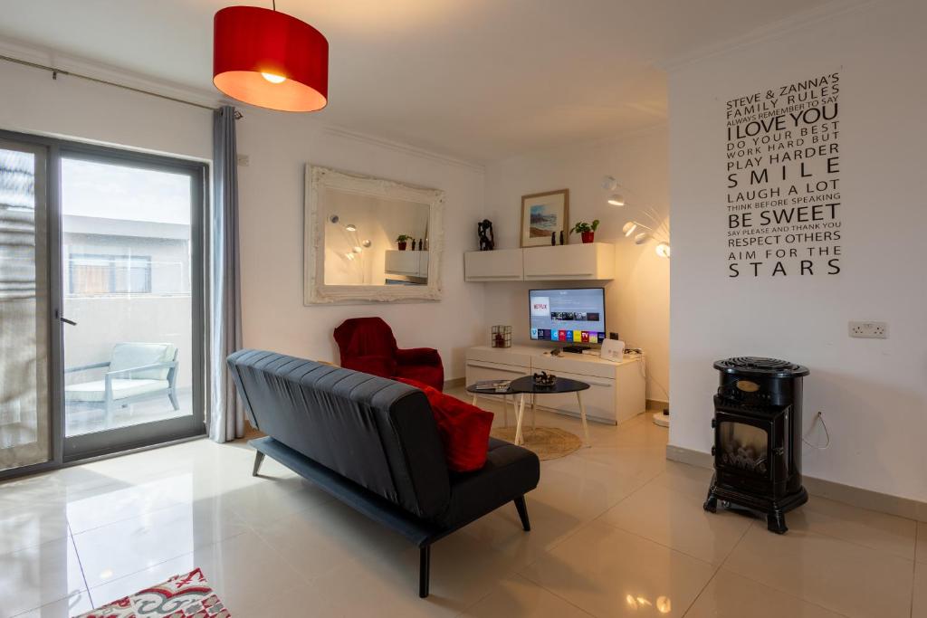 a living room with a chair and a stove at Penthouse Near Paceville with Private Terrace by QuickTrips in Is-Swieqi