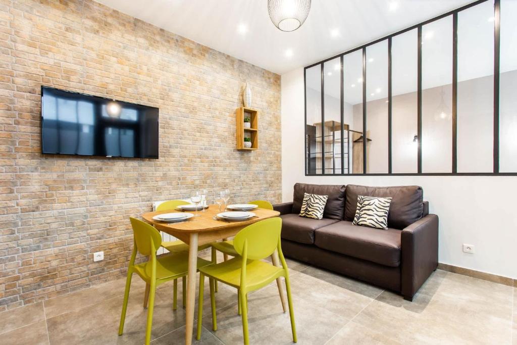 un salon avec une table et un canapé dans l'établissement Amazing apartment - 1BR 4P - Bastille, à Paris