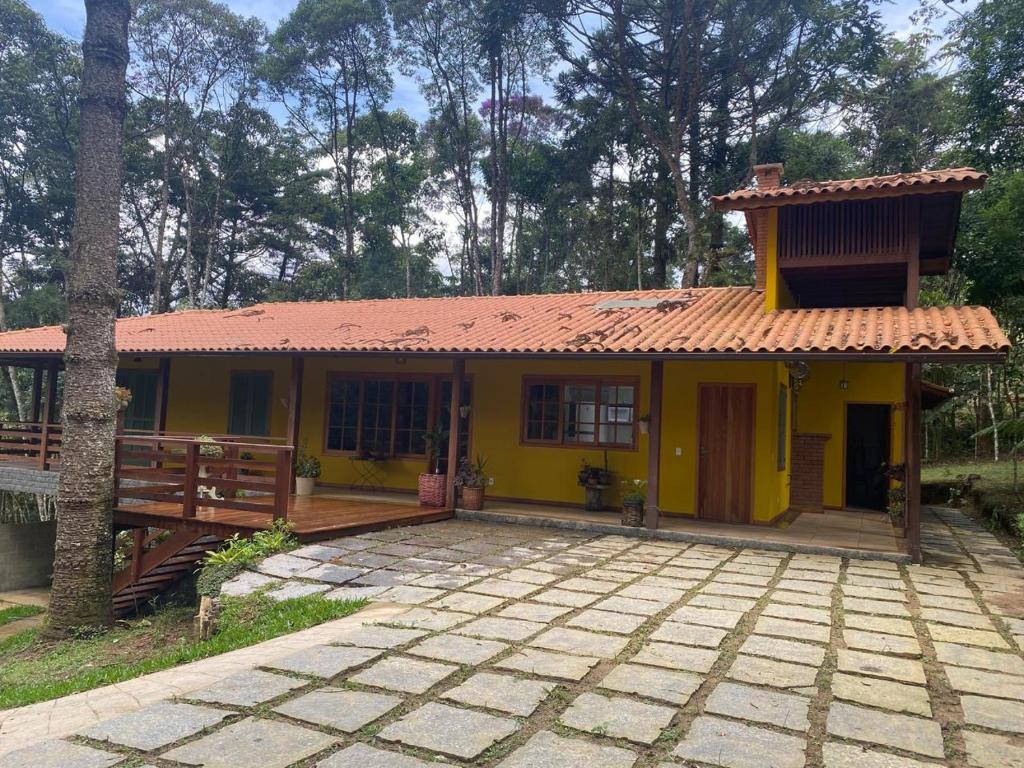 a small yellow house with a red roof at Yellow House Santa Clara in Bocaina de Minas