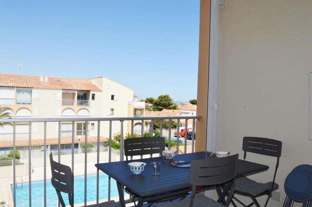 d'une table et de chaises sur un balcon avec vue sur la piscine. dans l'établissement NP170-A259 Appartement 2 pièces mezzanine Narbonne Plage, à Narbonne-Plage