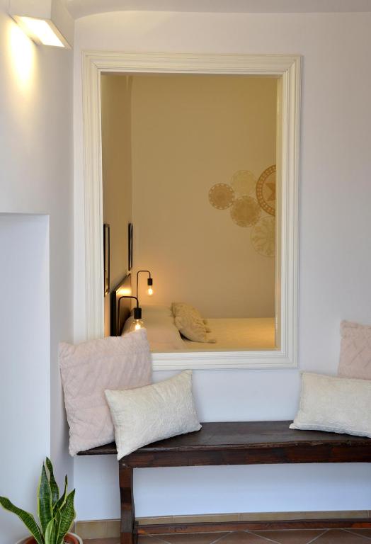 a mirror in a room with a bench and a chair at Dimora il Capitello in Cisternino