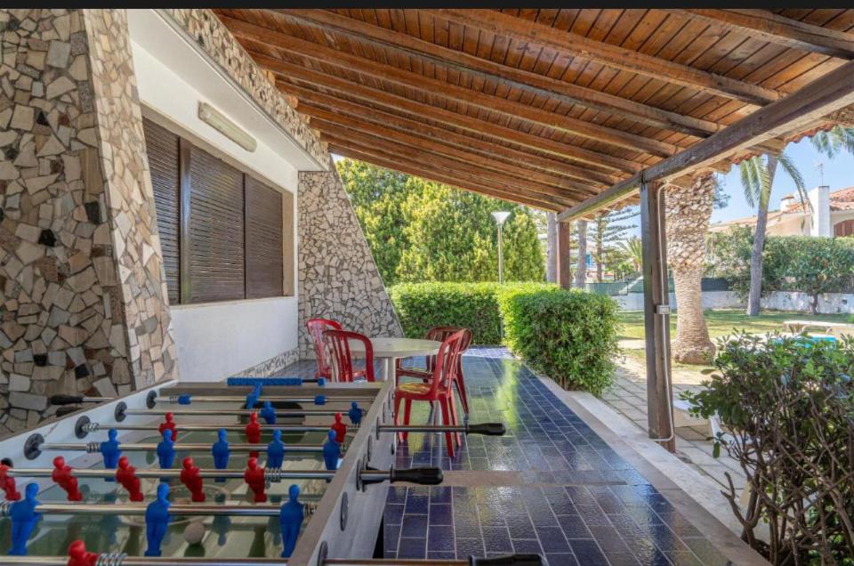 un groupe d'oiseaux assis sur une table sur un patio dans l'établissement B&S Beach villa con piscina, à Fontane Bianche