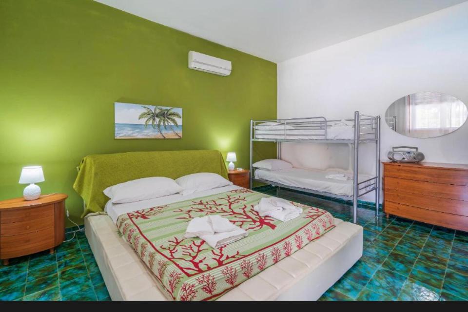 une chambre avec un lit et un lit superposé dans l'établissement B&S Beach villa con piscina, à Fontane Bianche