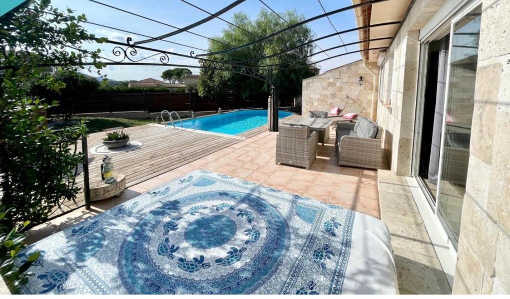 un patio avec une table et des chaises et une piscine dans l'établissement Villa 7 pers entre Cannes et St Tropez avec piscine au calme, à Puget-sur Argens