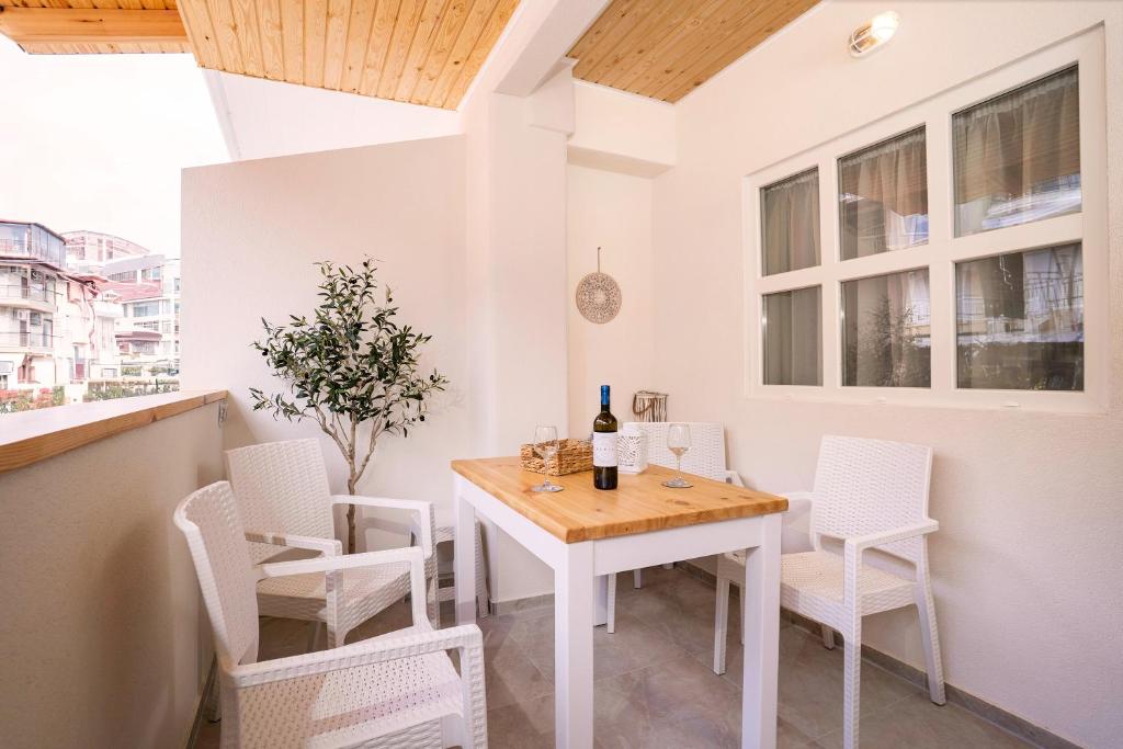 a white dining room with a table and chairs at Xenia Inn Paralia in Paralia Katerinis