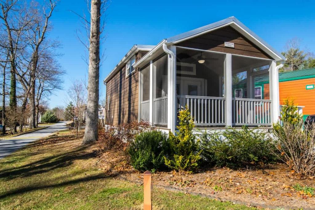 a home with a porch and a colorful house at Cozy 1BR Tiny Home with Pool Access and Free Tix in Flat Rock
