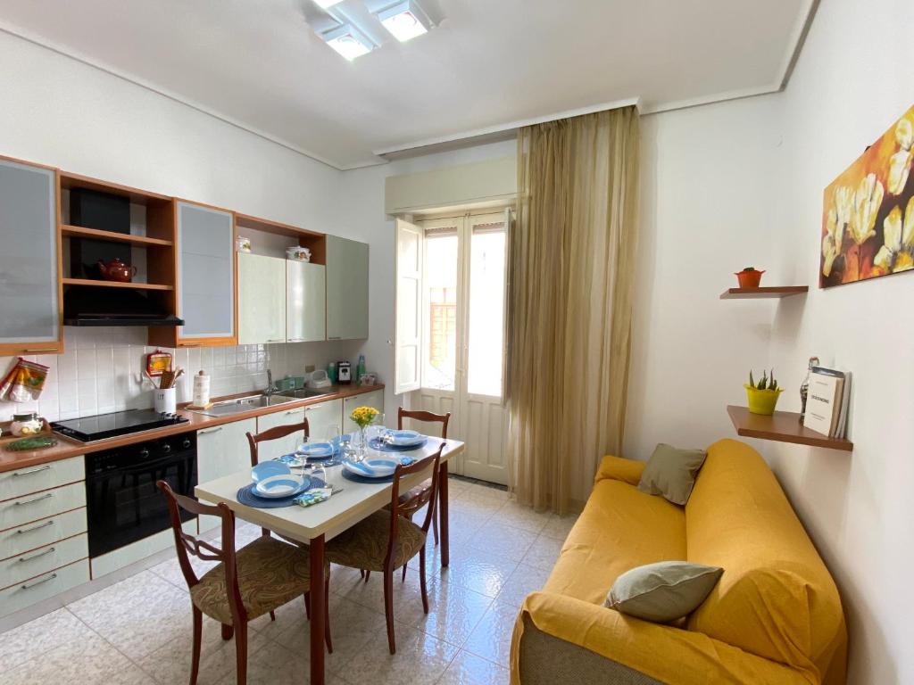 Una sala de estar con un sofá amarillo y una mesa. en La casa di Palma, en Pachino