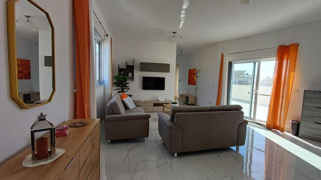 a living room with two couches and a mirror at Tan-Nanniet Penthouse in Dingli in Dingli