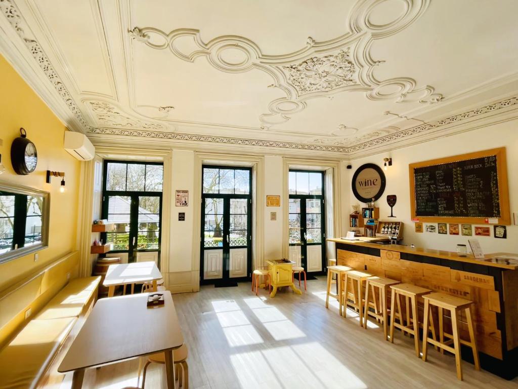 una habitación con bar, mesas y sillas en Porto Wine Hostel, en Oporto