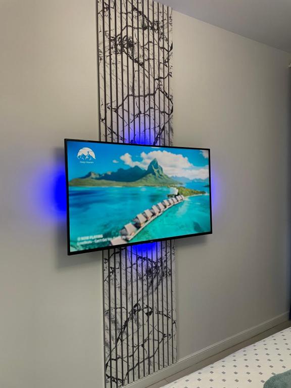 a flat screen tv hanging on a wall at App Town North Pipera 32 in Voluntari