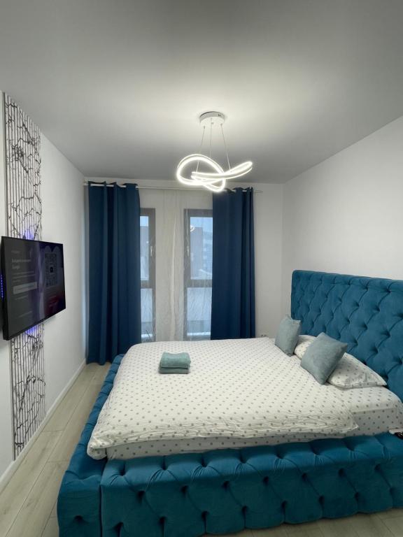 een blauwe bank in een kamer met een bed bij App Town North Pipera 23 in Voluntari