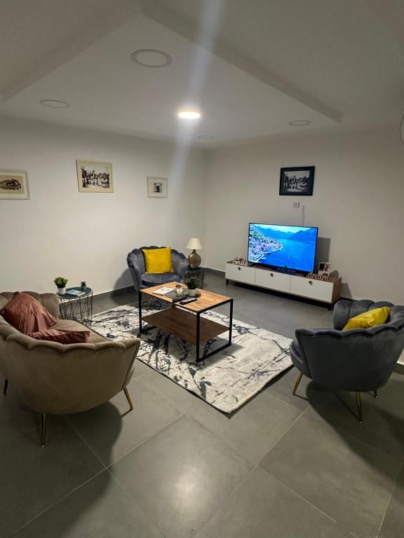 a living room with two couches and a flat screen tv at Apartman Una in Nikšić