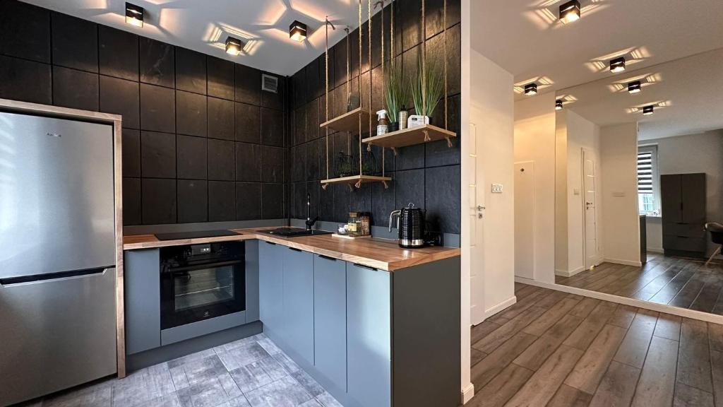a kitchen with a refrigerator and a counter top at Apartament Skandynawski Sienkiewicza 13 in Kielce