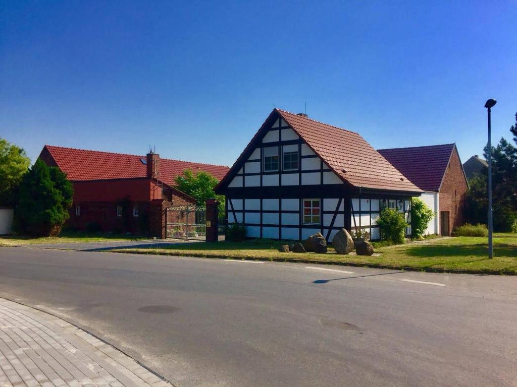 una casa en blanco y negro al lado de una calle en FeWo Schöna45, en Schöna