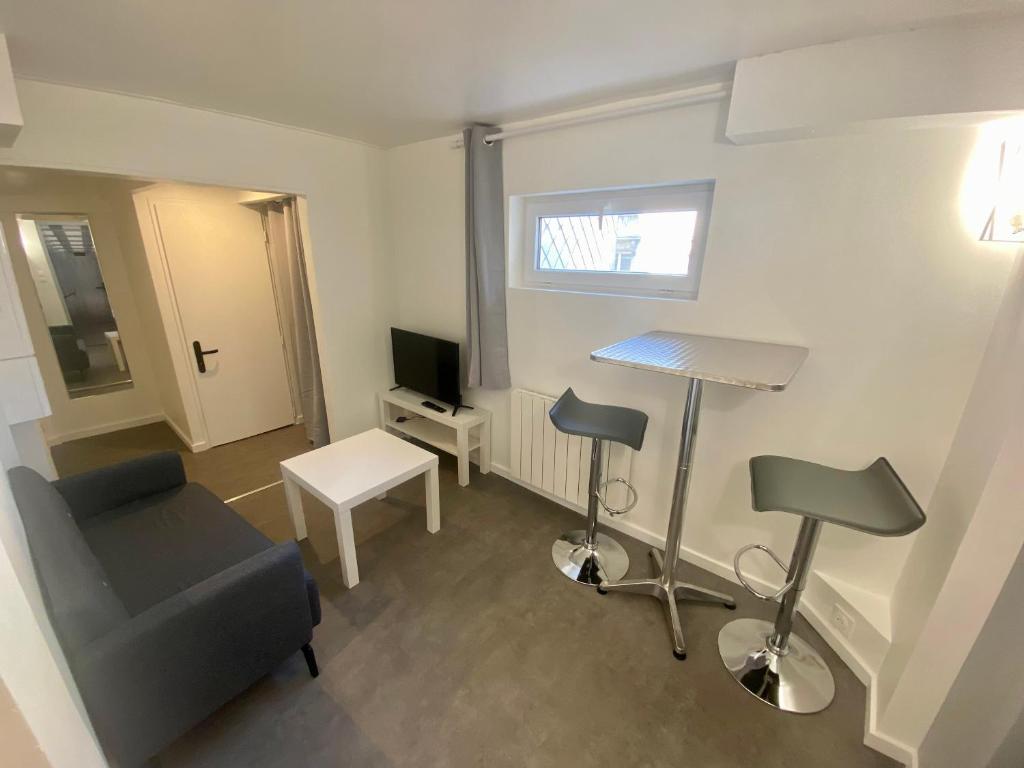 Elle comprend un petit salon avec une chaise et un bureau. dans l'établissement Séjour au cœur du centre, proche de la République - 138, à Rouen