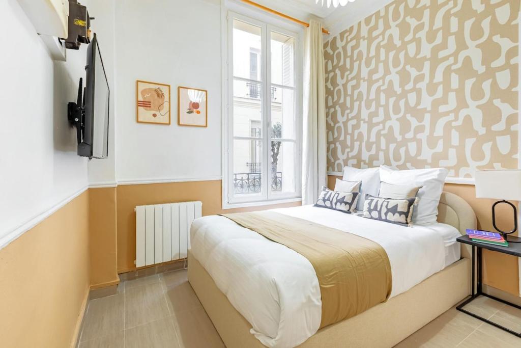 une chambre avec un grand lit et une fenêtre dans l'établissement Cozy Studio Paris Centre Montparnasse - II, à Paris