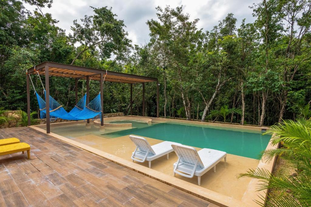 einen Pool mit zwei Stühlen und einer Schaukel in der Unterkunft Casa Jaguar Villa 1 in Playa del Carmen