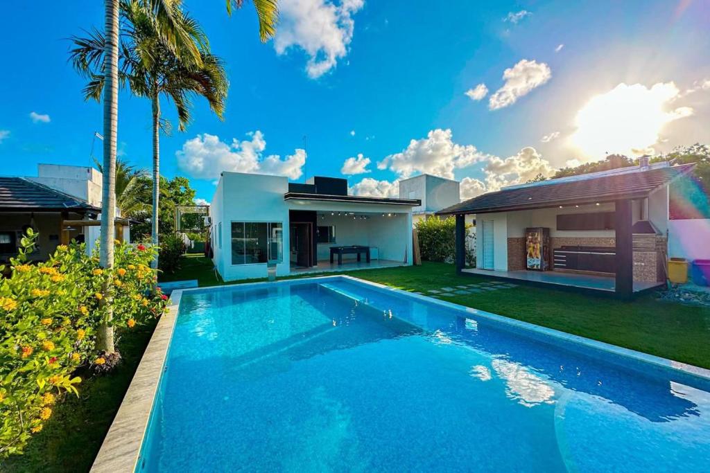 una villa con piscina e una casa di Casa Brilho Do Mar a Camaçari