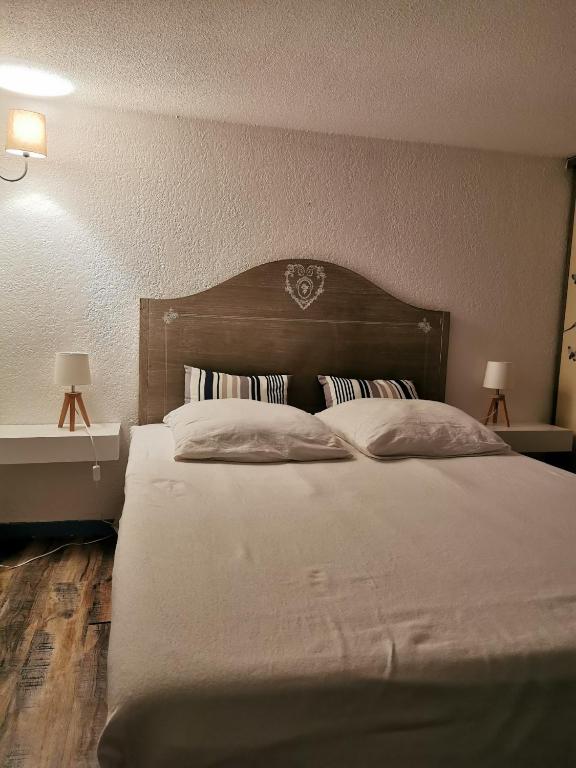 une chambre avec un grand lit avec une tête de lit en bois dans l'établissement Maisonnette vue mer zone naturiste, à Leucate-Plage