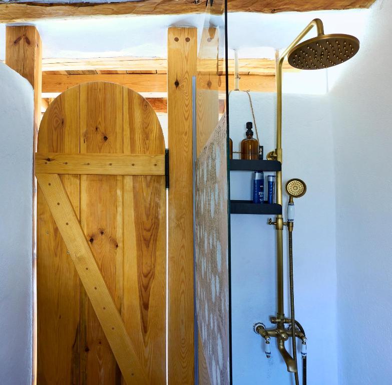 a shower stall with a wooden door in a room at Casa Rural La Encalá in Ayna