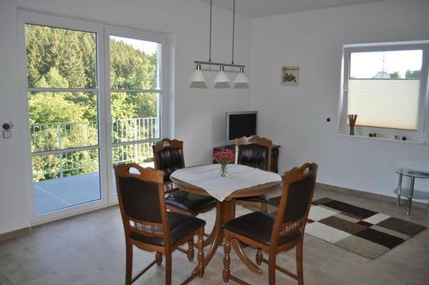 a dining room with a table and chairs in a room at Ferienwohnung Am Waldesrand in Schmallenberg