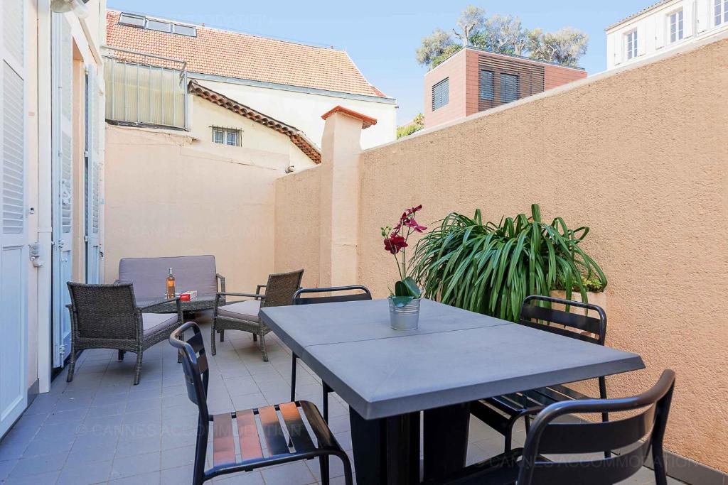 un patio avec tables et chaises sur un balcon dans l'établissement Bessons, à Cannes